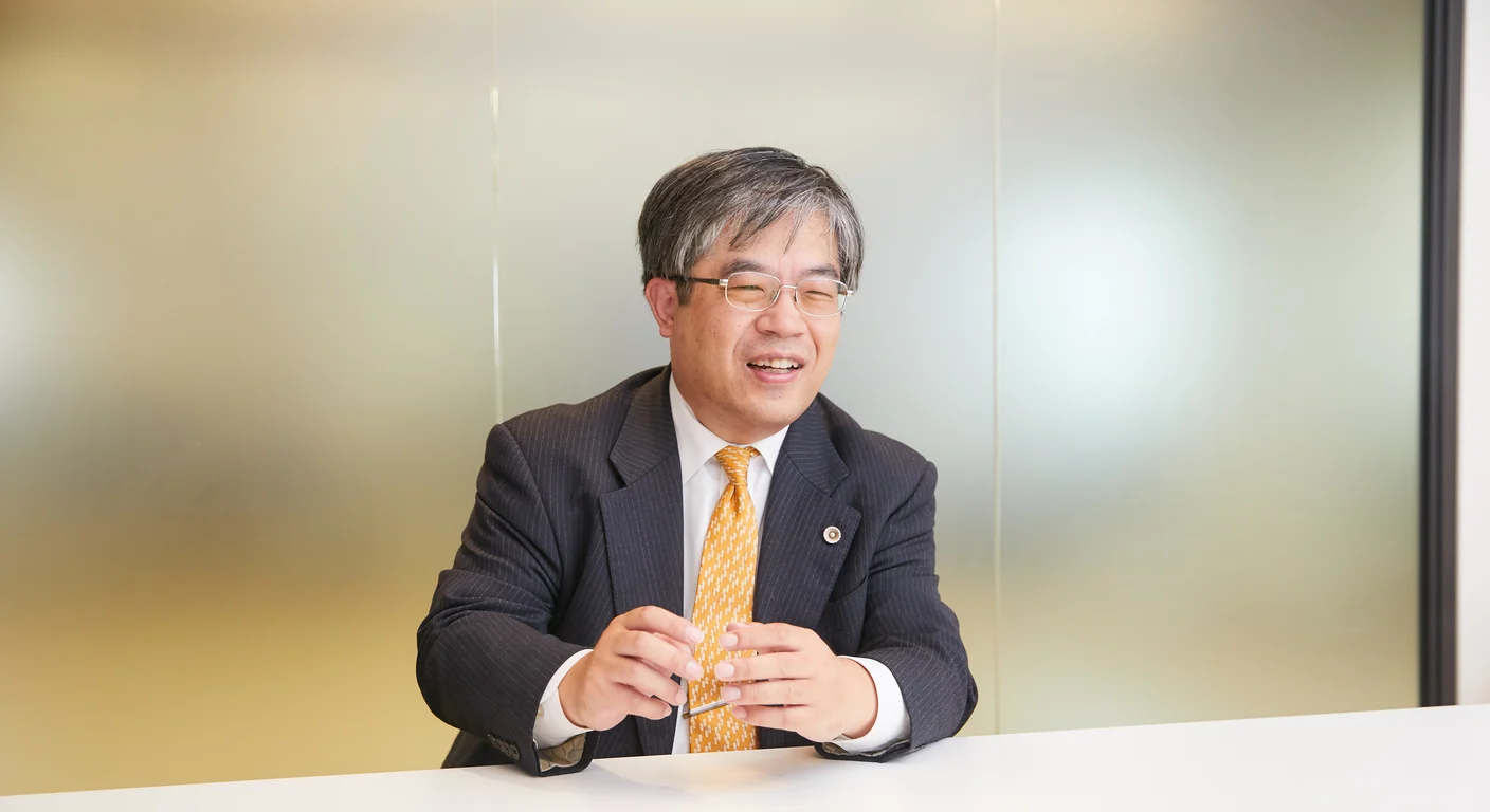事務所で両手を重ねて話を聞く弁護士