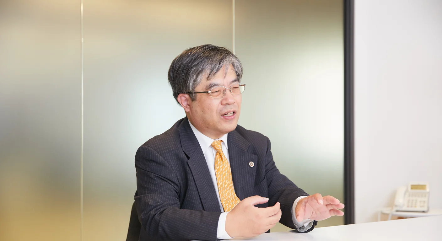 事務所で手元の資料を示しながら説明する弁護士